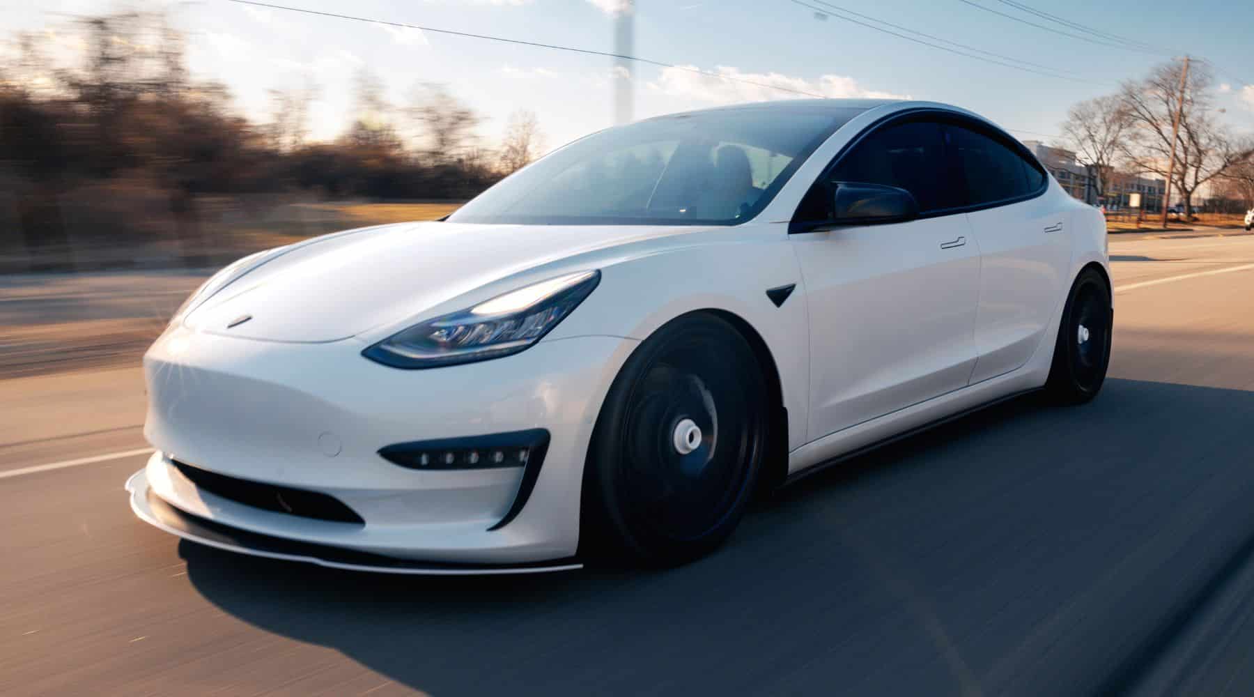 White Tesla driving on the road