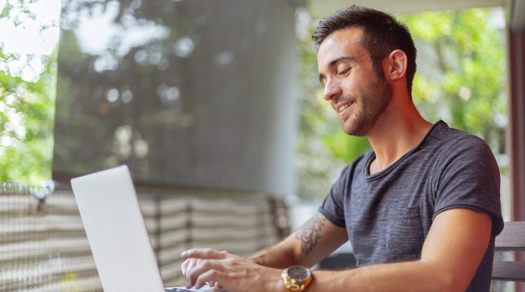 Man typing on his laptop at a cafe