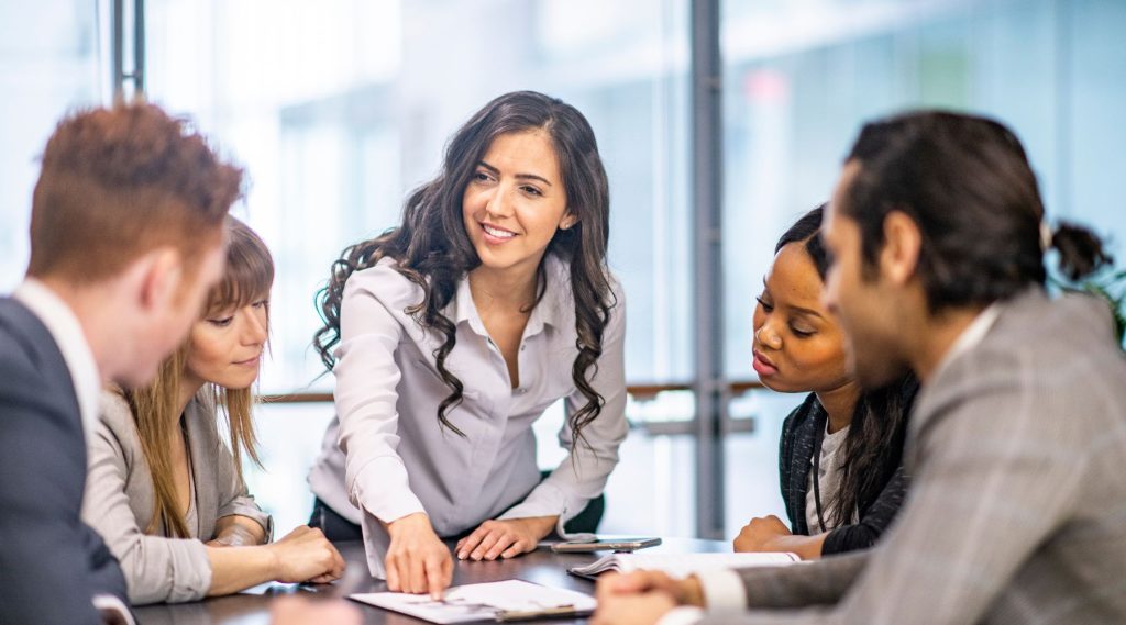 Woman speaking to colleagues at business meeting