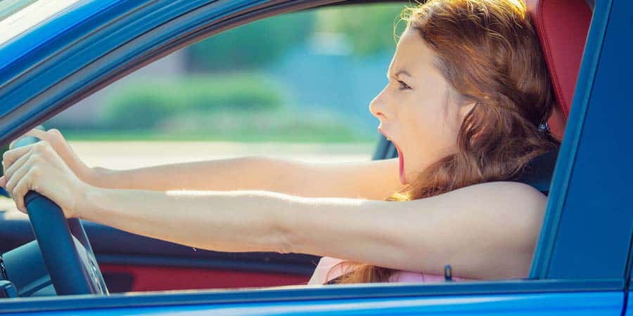 Woman screaming while driving with road rage in traffic